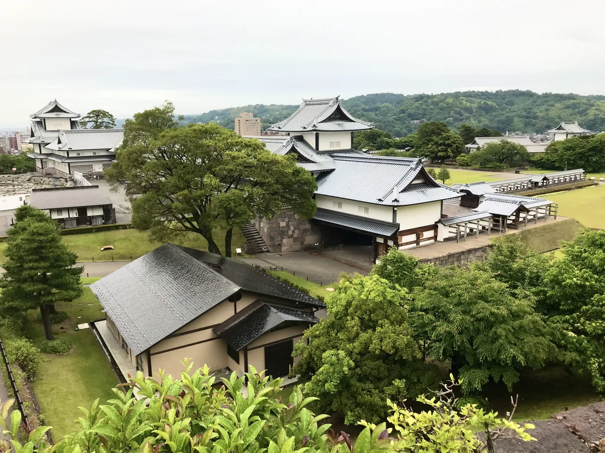 緑に囲まれた金沢城公園の櫓と石垣を高台から望む（石川県金沢市）