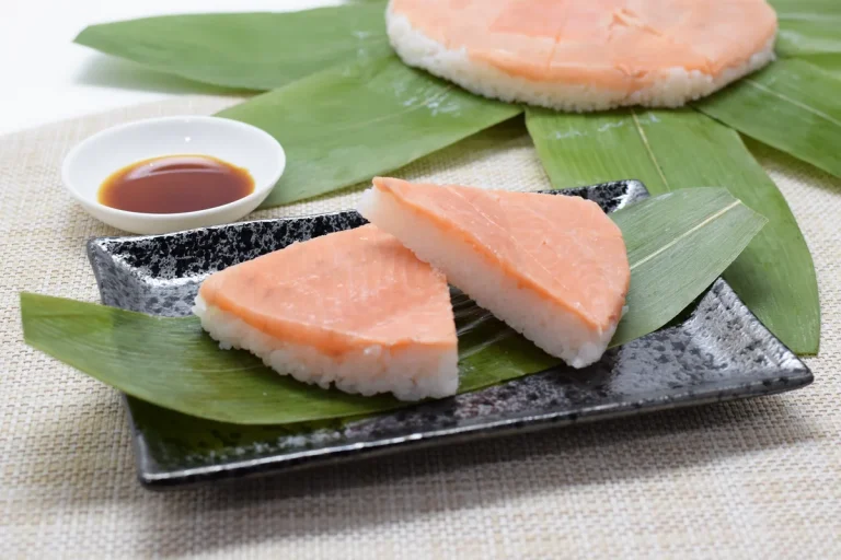 笹を敷いた富山名産のますのすし　切り分けた二切れと醤油